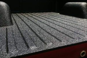 Close-up of a pickup truck bed with a textured Rhino Liner coating, showcasing durable, non-slip protection.